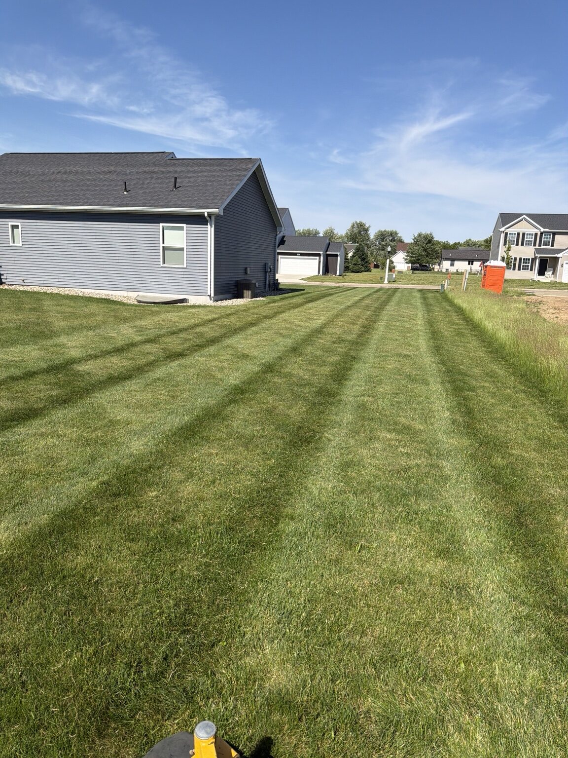 Freshly striped lawn maintained by Precision Grounds Co.
